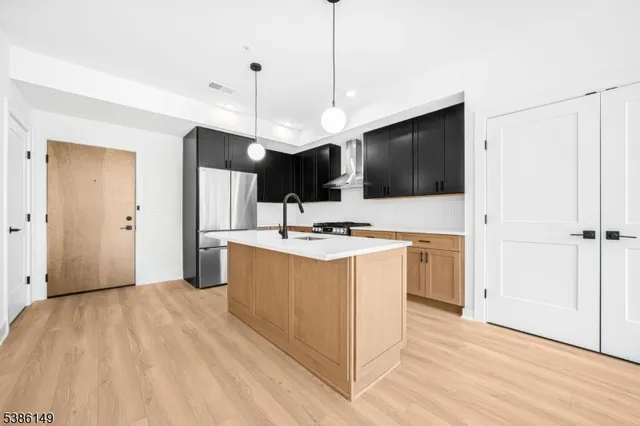 a view of kitchen with stainless steel appliances kitchen island sink and living room view