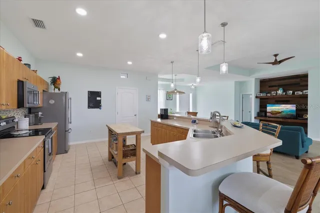a kitchen with a sink a refrigerator and chairs
