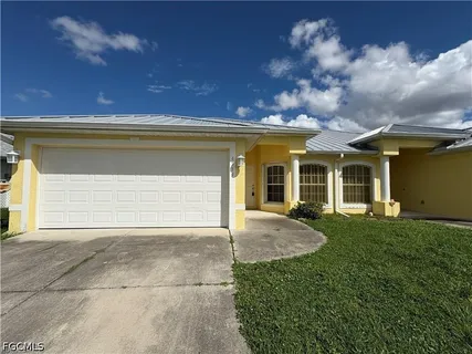 a view of a house with brick walls and a yard with plants