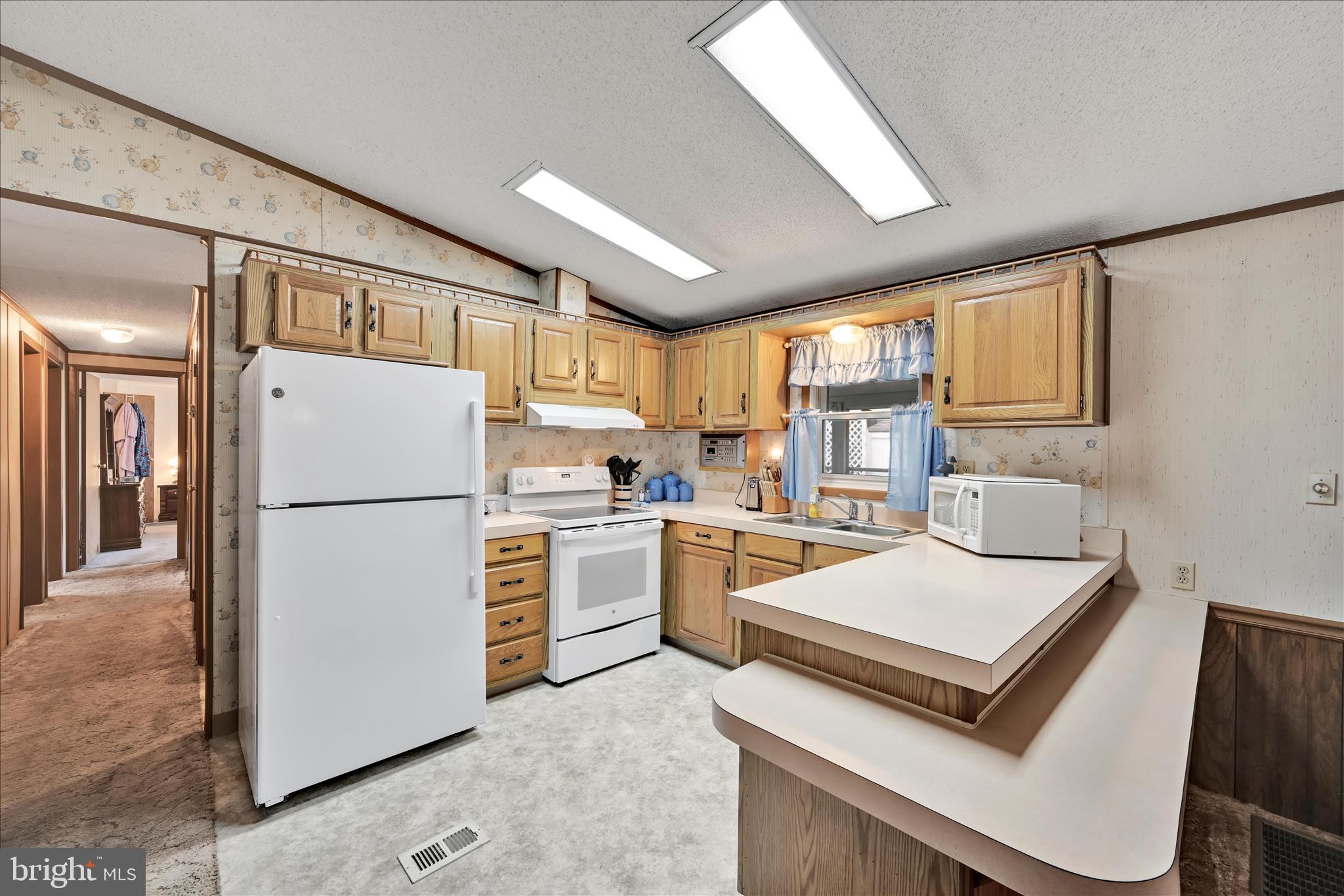 64 Maple Avenue Manheim, PA 17545 - Photo 13 of 36 a kitchen with a refrigerator a stove top oven a sink and cabinets