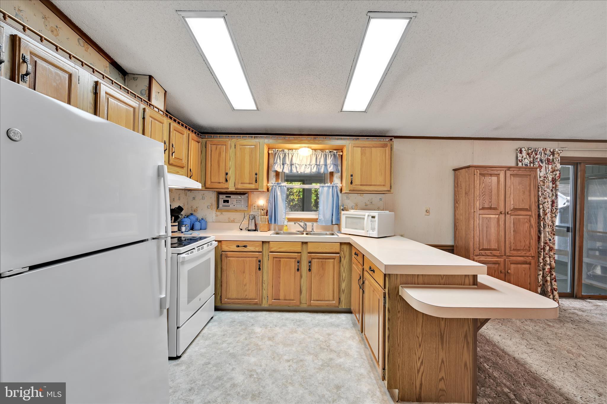64 Maple Avenue Manheim, PA 17545 - Photo 17 of 36 a kitchen with granite countertop a sink a stove a refrigerator and a refrigerator