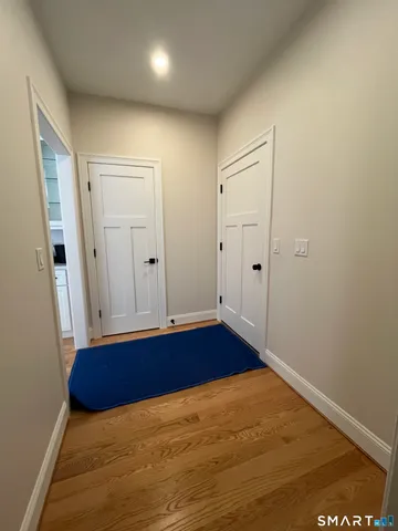 a view of hallway with wooden floor and cabinet