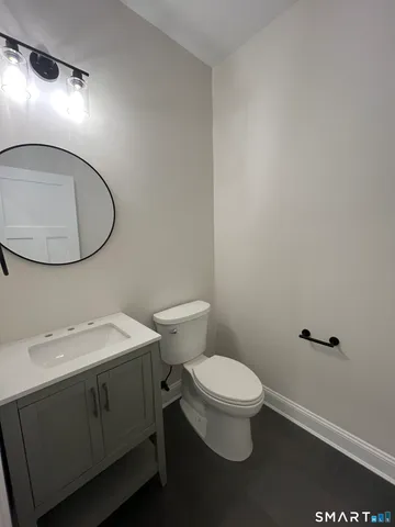 a bathroom with a toilet a sink and mirror