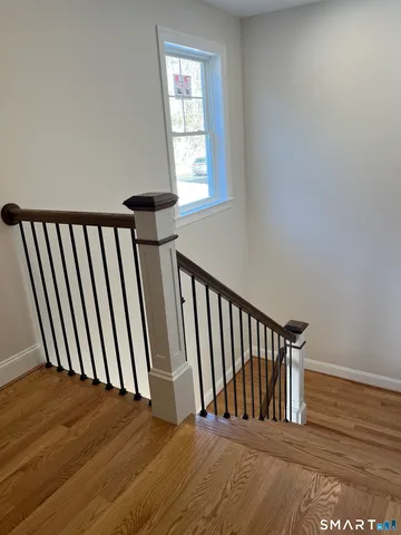 a view of staircase with railing and a window