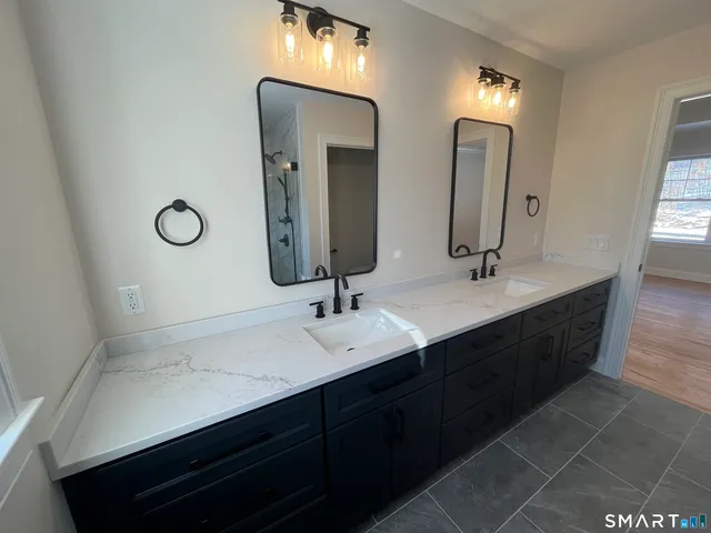 a bathroom with double vanity sinks and a mirror
