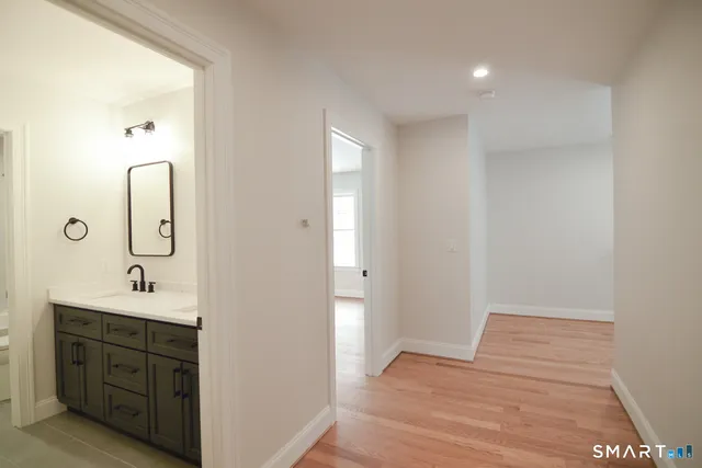 a spacious bathroom with a double vanity sink a mirror and shower