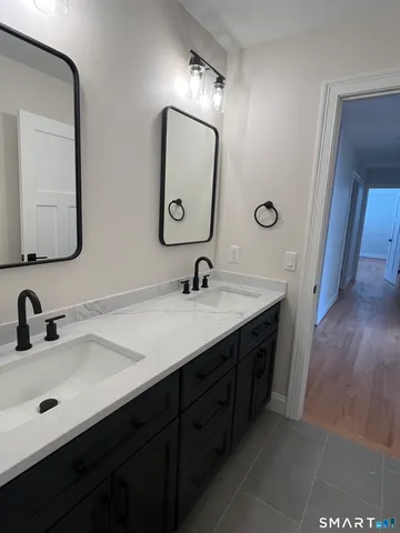 a bathroom with a double vanity sink and a mirror