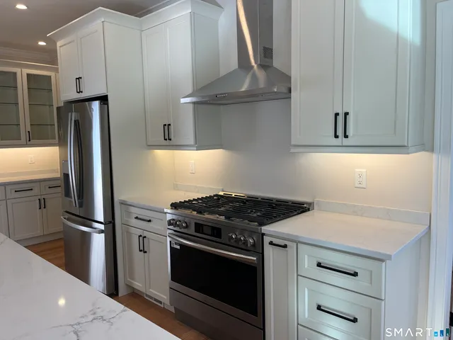 a kitchen with granite countertop a stainless steel stove and refrigerator