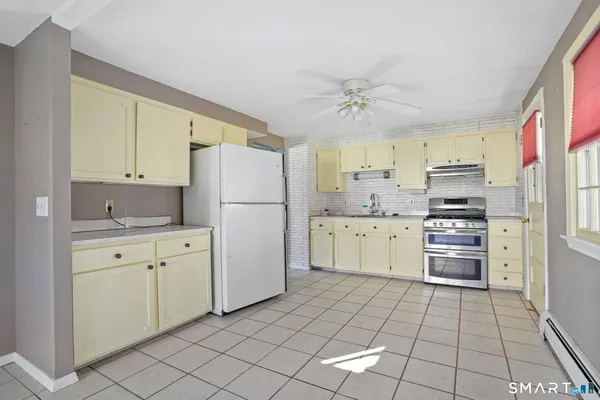 a kitchen with granite countertop white cabinets and stainless steel appliances