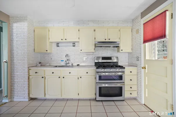 a kitchen with a refrigerator a stove top oven and cabinets