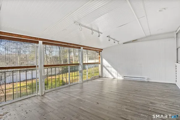 a view of a big room with wooden floor and windows