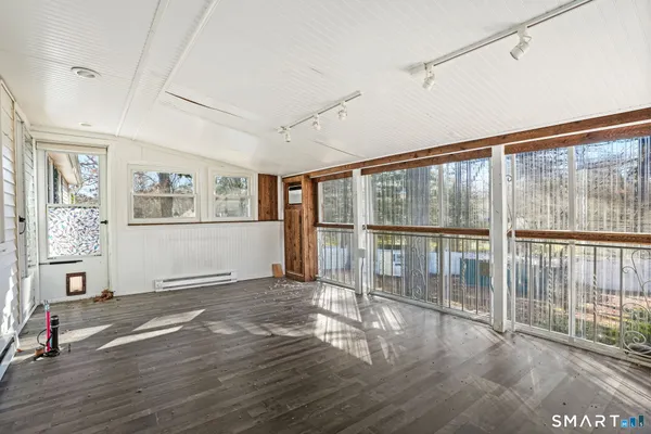 an empty room with a window and ceiling fan
