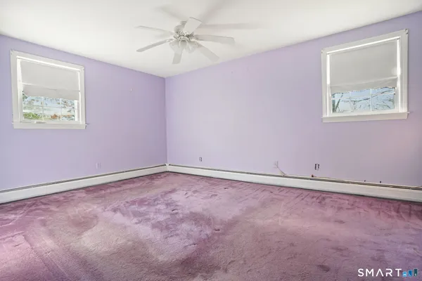 an empty room with fan and windows