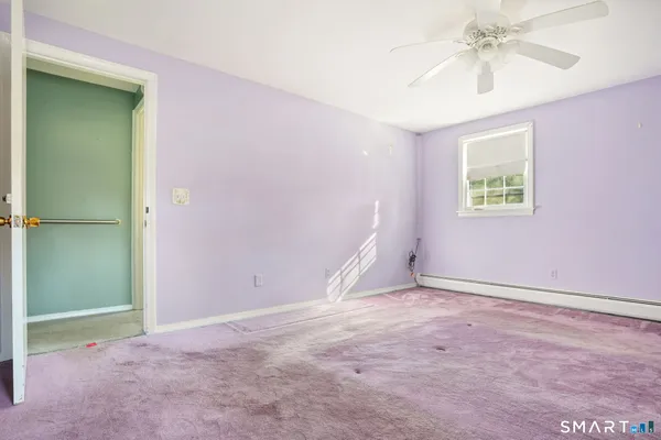 an empty room with windows and chandelier fan