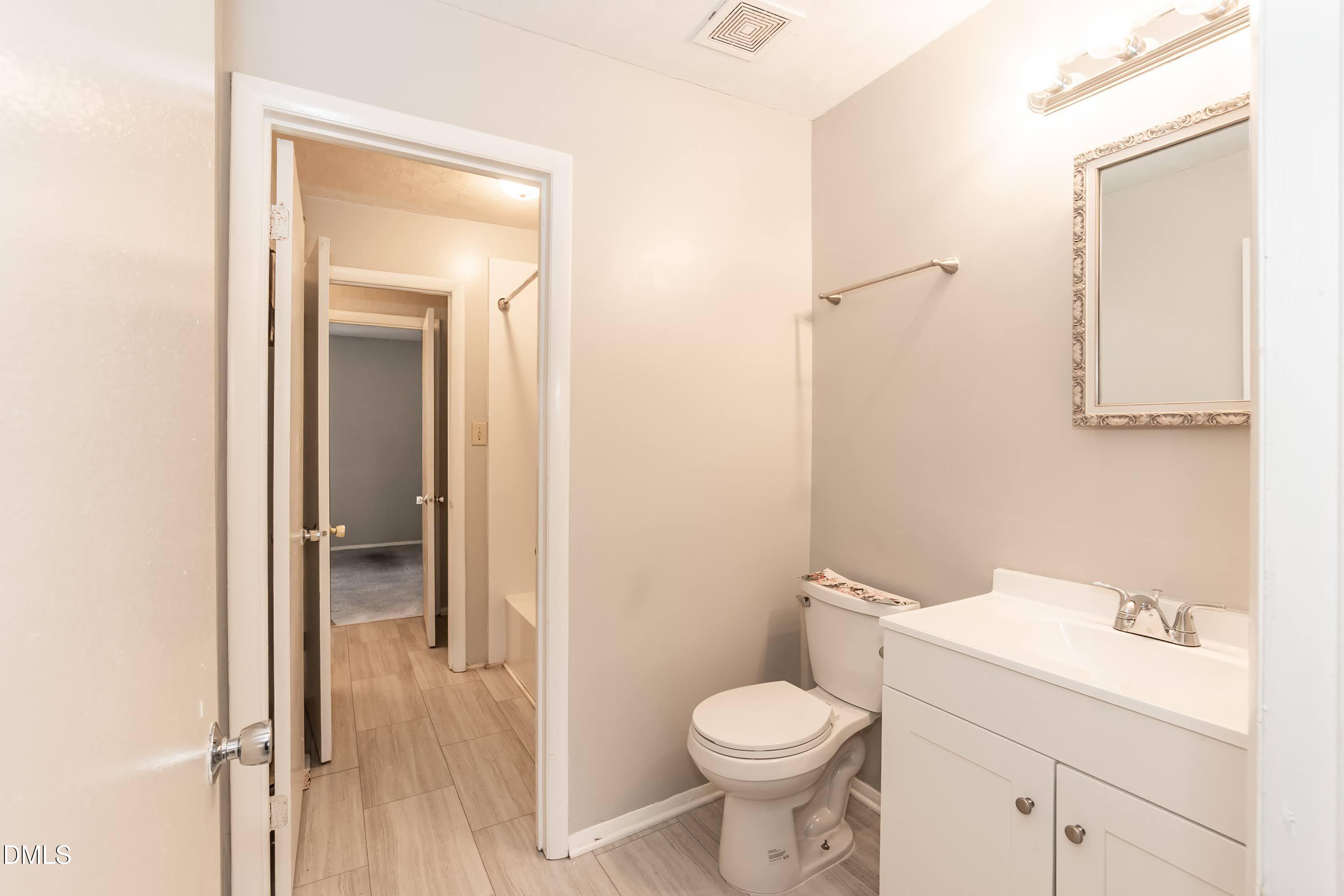 1231 Schaub Drive Raleigh, NC 27606 - Photo 12 of 23 a white toilet sitting next to a bathroom sink