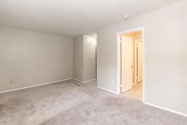 an empty room with closet and a bathroom