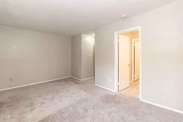 an empty room with closet and a bathroom