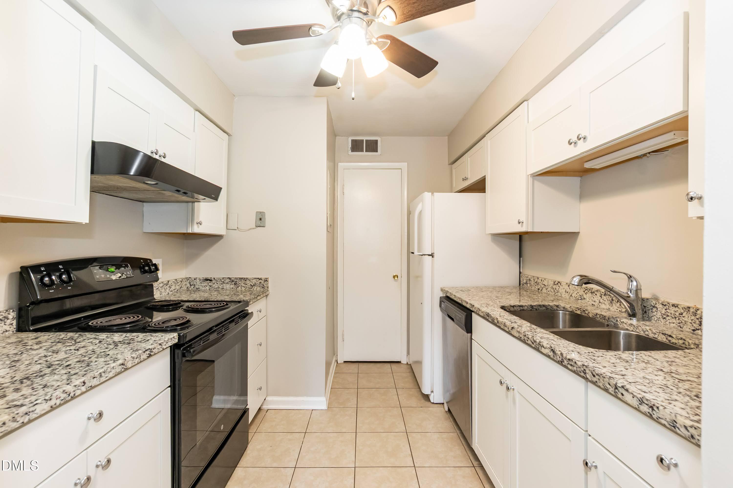 1231 Schaub Drive Raleigh, NC 27606 - Photo 7 of 23 a kitchen with stainless steel appliances granite countertop a sink stove and refrigerator