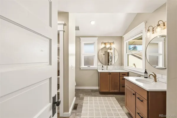 a bathroom with a double vanity sink mirror and bathtub