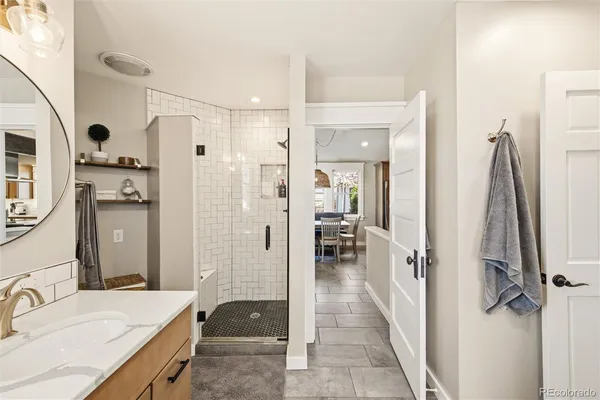 a bathroom with a granite countertop sink mirror and shower