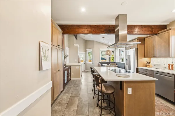 a large kitchen with a table chairs refrigerator and cabinets