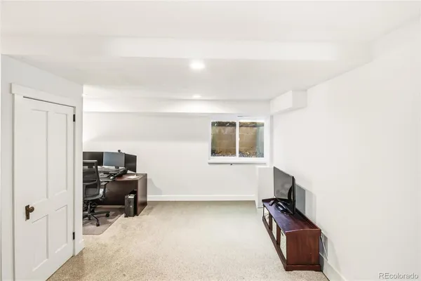 a view of a workspace with furniture and a window