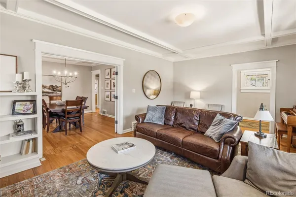 a living room with furniture a clock on wall and a table