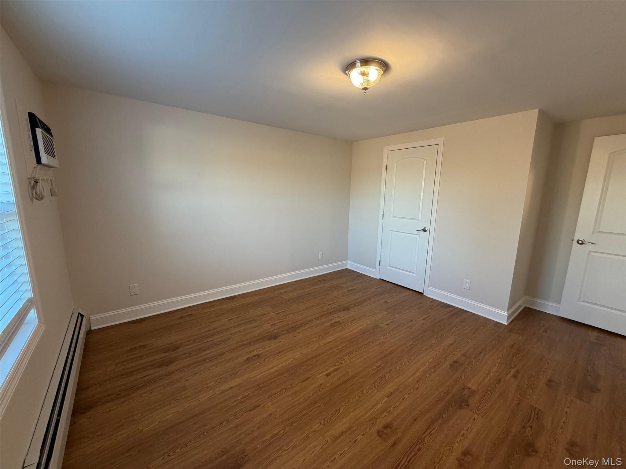 6 Marwood Road South Port Washington, NY 11050 - Photo 8 of 13 an empty room with wooden floor and windows