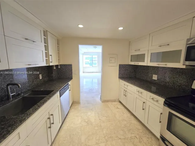 a kitchen with stainless steel appliances a sink stove and cabinets