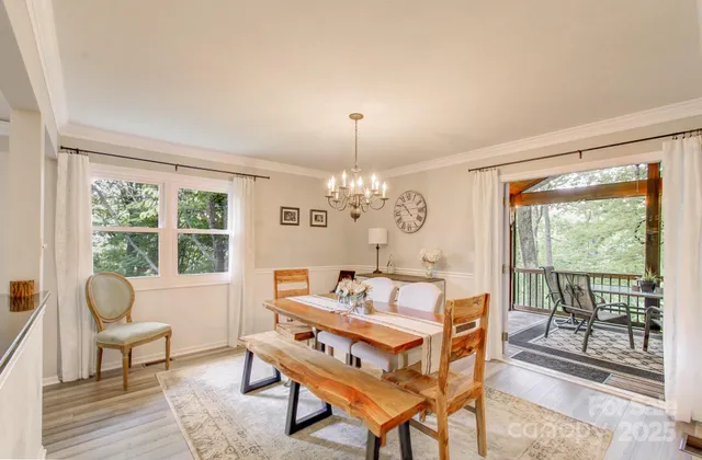 a dining room with wooden floor a chandelier a glass table and chairs