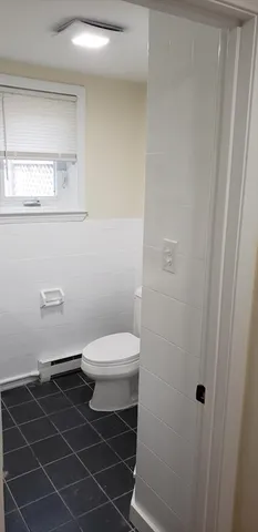 a bathroom with a toilet a sink and a window