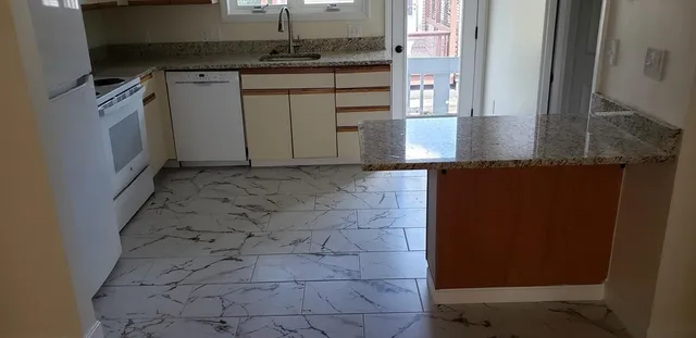 a kitchen with granite countertop a sink and a stove