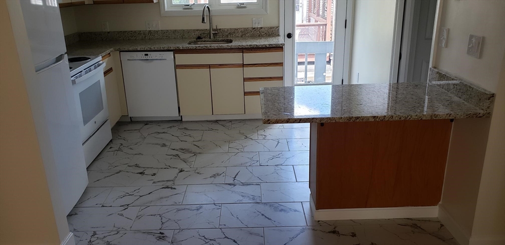 8 Rollins Court, Unit 8 Cambridge, MA 02139 - Photo 7 of 9 a kitchen with granite countertop a sink and a stove