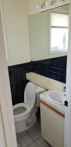 a bathroom with a sink a toilet a window and vanity