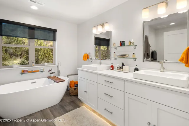 a spacious bathroom with a large tub sink and mirror