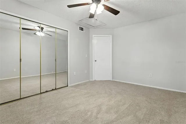 a view of an empty room with a chandelier fan