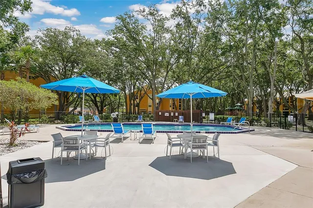 a patio with a table and chairs under an umbrella