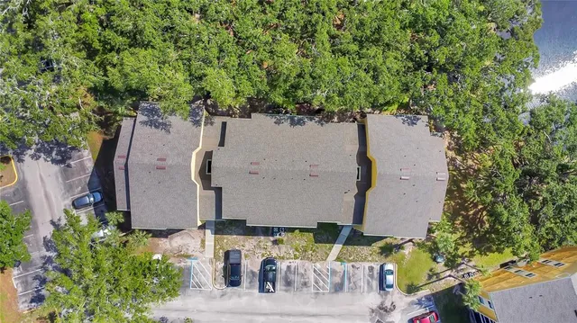 an aerial view of a house with a yard and large tree