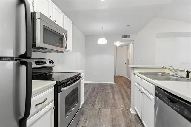 a kitchen with a sink stove and microwave