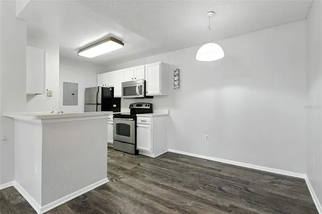 a kitchen with cabinets stainless steel appliances and wooden floor