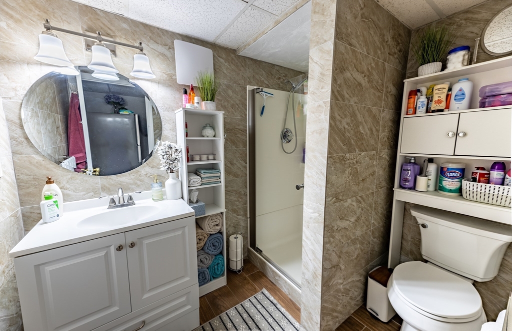 32 Farmington Street, Unit 1 Worcester, MA 01603 - Photo 18 of 25 a bathroom with a toilet sink vanity and mirror