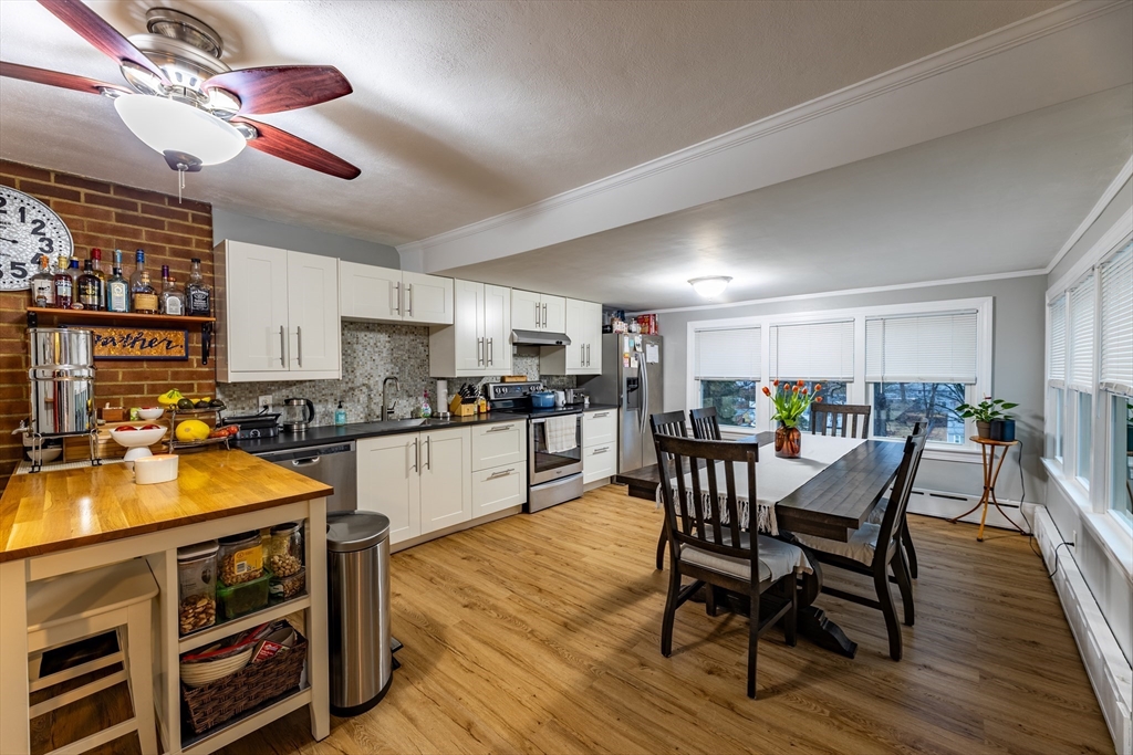 32 Farmington Street, Unit 1 Worcester, MA 01603 - Photo 2 of 25 a kitchen with stainless steel appliances wooden floors and wooden cabinets