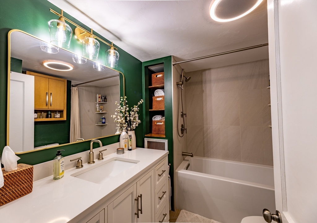 32 Farmington Street, Unit 1 Worcester, MA 01603 - Photo 9 of 25 a bathroom with a tub a sink and a large mirror