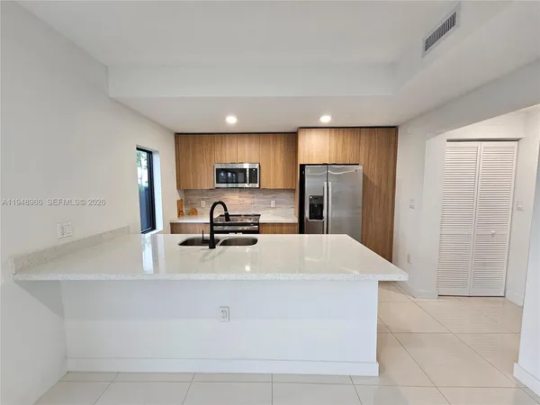 a kitchen with stainless steel appliances a refrigerator sink stove microwave and cabinets