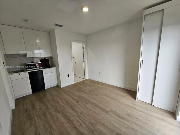 a kitchen with granite countertop a refrigerator stove a sink and dishwasher with wooden floor