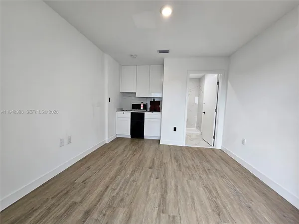 a view of a kitchen with a sink and a refrigerator