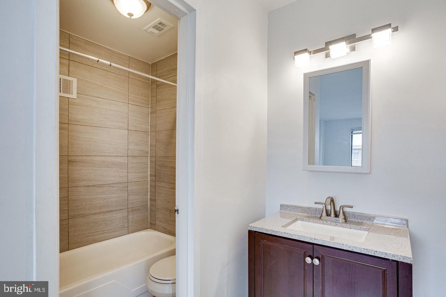 1836 Metzerott Road, Unit 2025 Adelphi, MD 20783 - Photo 17 of 21 a bathroom with a granite countertop sink toilet and shower