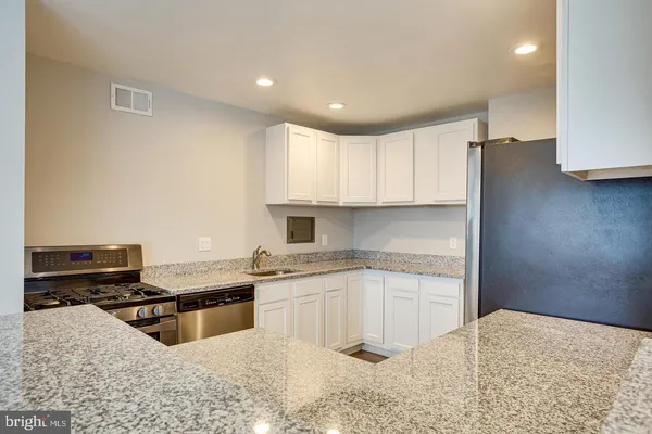 a kitchen with stainless steel appliances granite countertop a sink stove and refrigerator