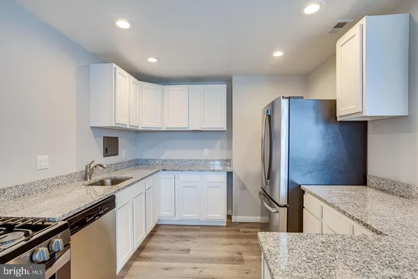 a view of granite countertop cabinets appliances and a window