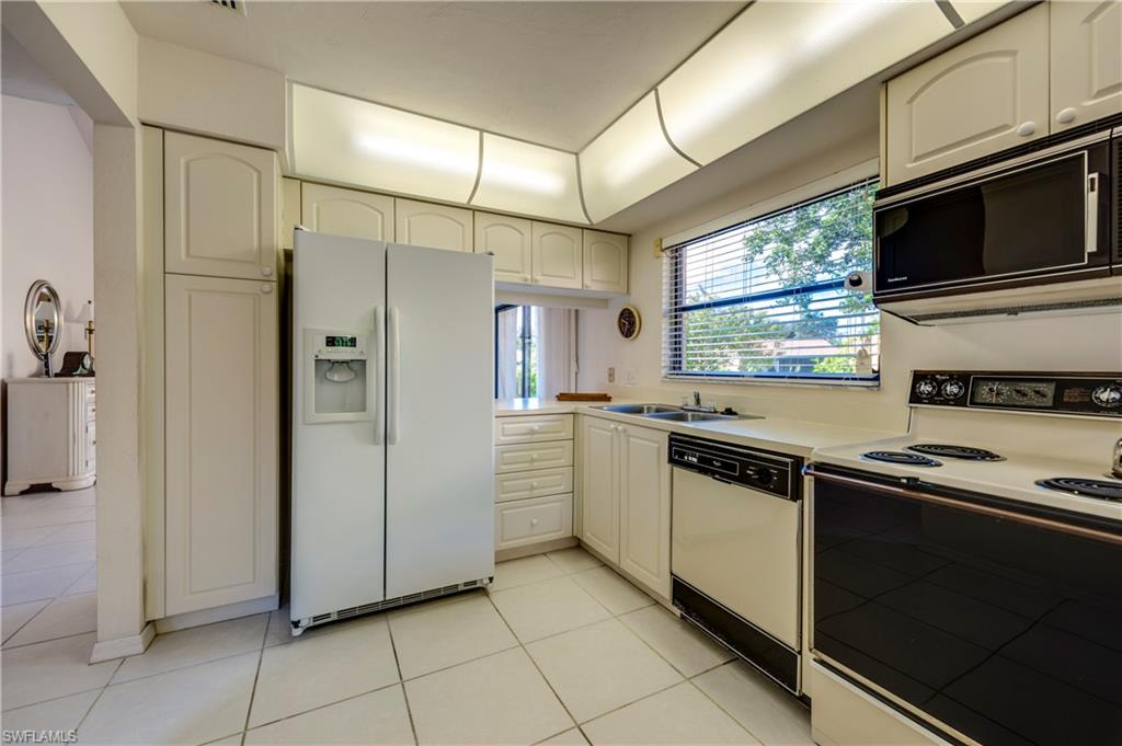 867 Reef Point Circle Naples, FL 34108 - Photo 14 of 32 Kitchen offers a pantry style cabinet & newer refrigerator